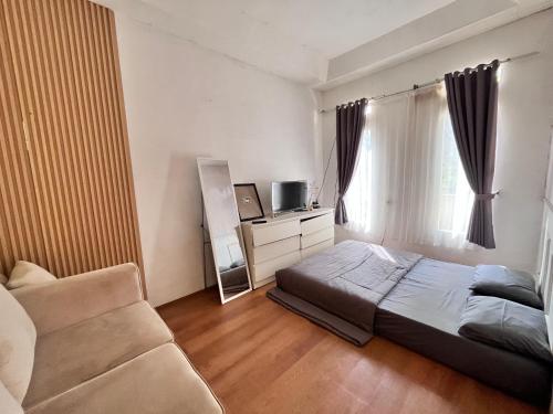 a bedroom with a bed and a couch and a window at Sanghiang Homestay in Batukaras