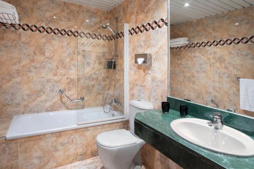 a bathroom with a toilet and a sink and a shower at Meliá Sol y Nieve in Sierra Nevada