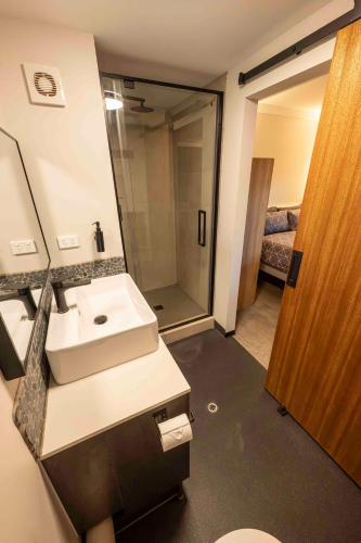 a bathroom with a sink and a toilet and a mirror at Oasis Newman in Newman