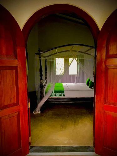 an open door to a bedroom with a bed at Pedlar Bungalow in Talpe