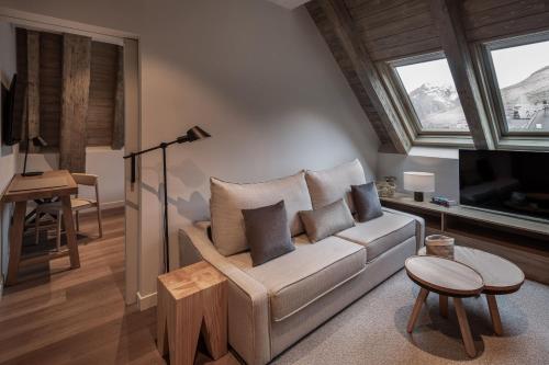 a living room with a couch and a table at MiM Baqueira member of Meliá Collection in Baqueira-Beret