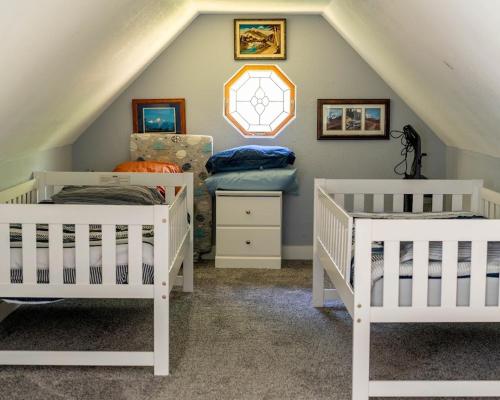a attic room with three cribs in a room at Blackberry Bunkhouse in Ashford