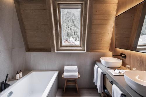a bathroom with a tub and two sinks and a window at MiM Baqueira member of Meliá Collection in Baqueira-Beret