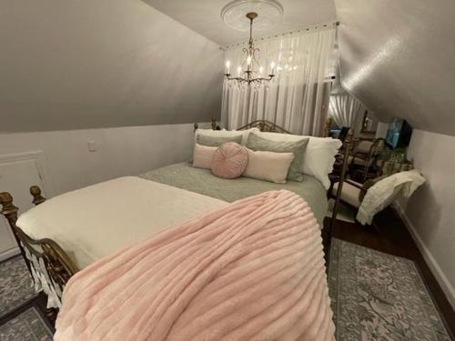 a bedroom with a large bed with a pink blanket on it at Two Sisters Inn at the Courtyard in Ahwahnee