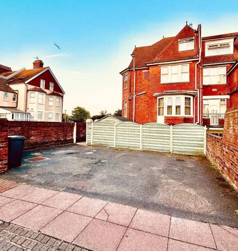 a parking lot in front of a brick house at SmartsWay Hotel & Wellness in Eastbourne