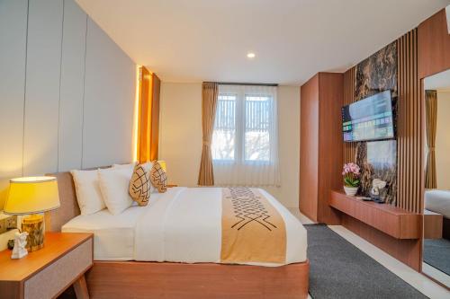 a hotel room with a bed and a television at Anandani Suites in Canggu