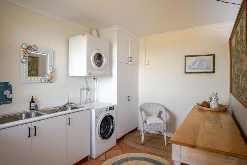a kitchen with a sink and a washing machine at The Mariner - Oceanfront Living in Falmouth