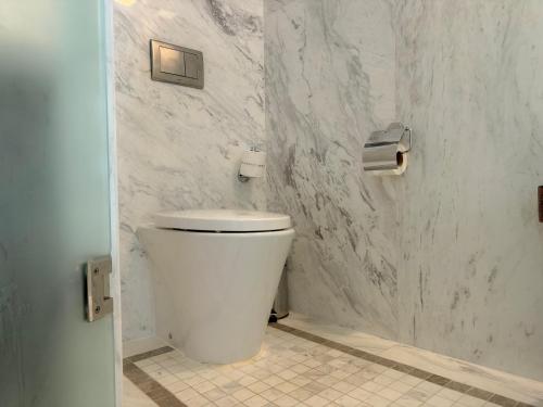 a white toilet in a bathroom with marble walls at Park Hyatt Siem Reap in Siem Reap