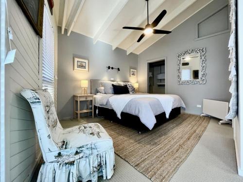 a bedroom with a bed and a chair in it at The Mariner - Oceanfront Living in Falmouth