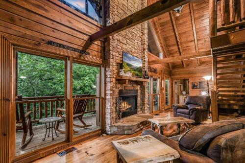 a living room with a fireplace in a log cabin at Absolute Bearadise cabin in Sevierville