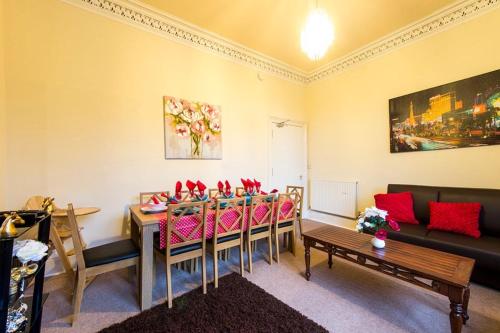 a living room with a table and chairs and a couch at Edinburgh Central Drumdryan ApartHotel in Edinburgh