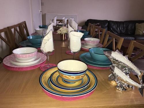 a table with plates and bowls on top of it at Edinburgh Central Drumdryan ApartHotel in Edinburgh