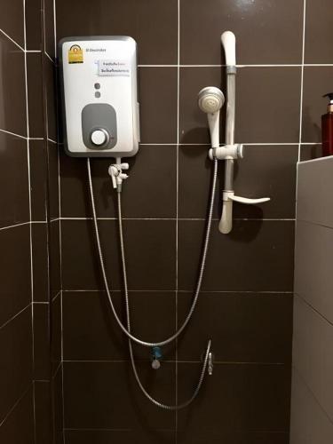 a bathroom with a hose hooked up to a shower at Baan Ing Daan in Ban Non Nam Thaeng