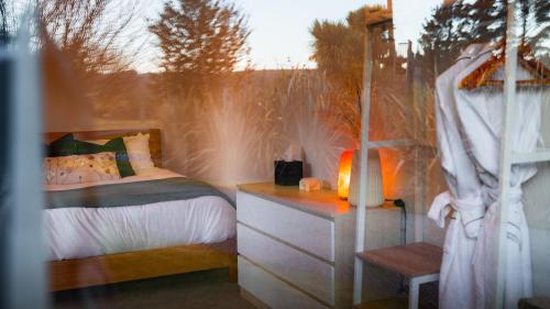 a bedroom with a bed and a desk with a window at Manawa Retreat in Whitecliffs