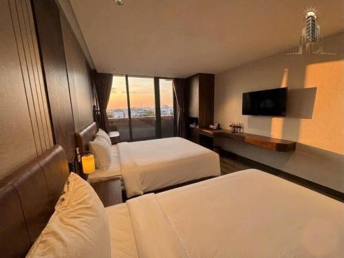 a hotel room with two beds and a flat screen tv at Thuỳ Dung 68 Hotel in Dong Hoi