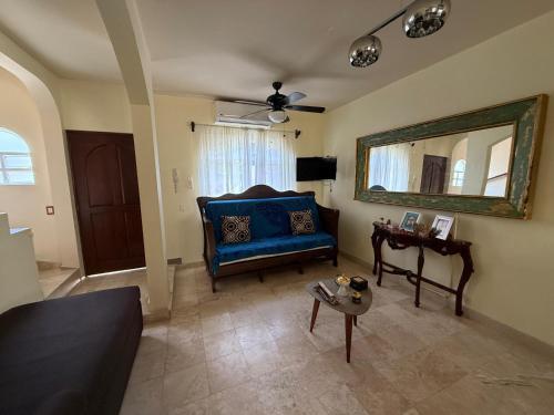 ein Wohnzimmer mit einem blauen Sofa und einem Spiegel in der Unterkunft Bellacozenza in Cabo San Lucas