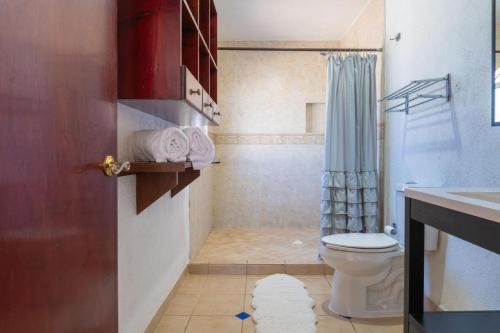 ein kleines Badezimmer mit Toilette und Dusche in der Unterkunft Bellacozenza in Cabo San Lucas