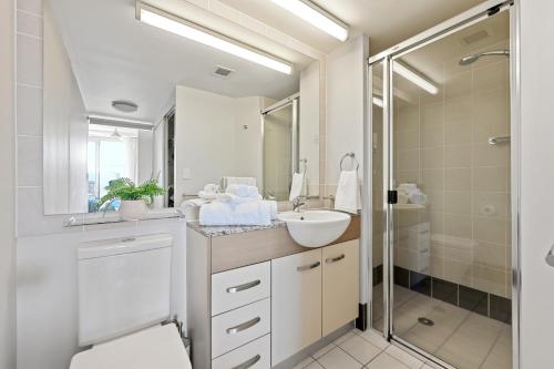 a white bathroom with a sink and a shower at Moana Condo | Close to Beach in Caloundra