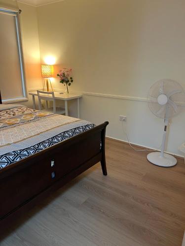 a bedroom with a bed and a fan at Private Rm3A in Elderslie in Elderslie