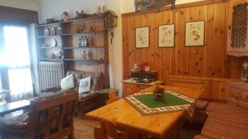 ボルカ・ディ・カドーレにあるTitti house Cortina Dolomitesのダイニングルーム(テーブル付)、木製の壁の部屋