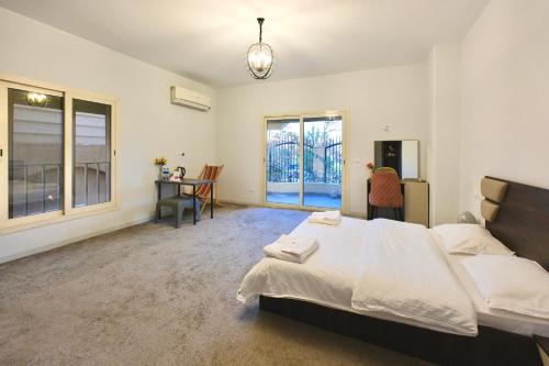 a bedroom with a bed and a desk and windows at 树屋民宿 in Cairo