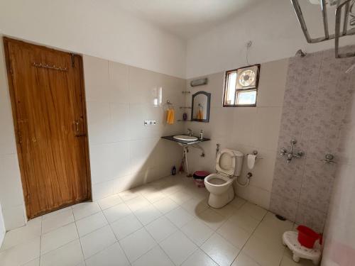 a bathroom with a toilet and a sink at LRX Retreats in Chaubattia