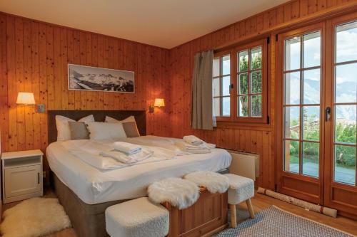 a bedroom with a large bed with white sheets at Chalet Belle Poncke by Jolidi in Nendaz