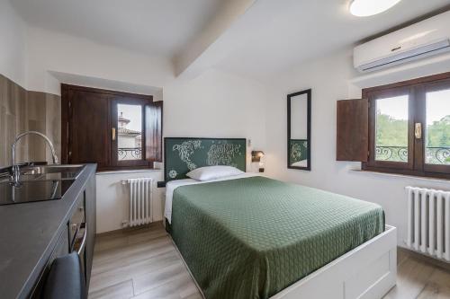 a bedroom with a bed and a kitchen with a sink at Maserati House - H24 in Modena