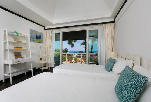 a bedroom with a white bed and a balcony at Katamanda Villa Jade A6 Seaview Kata Beach in Kata Beach