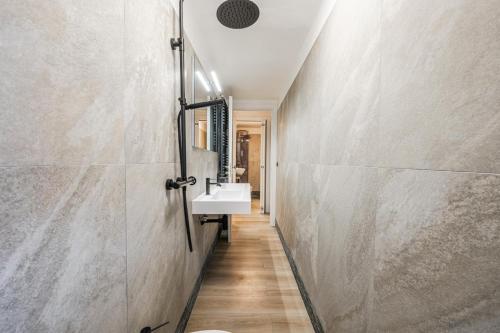 a corridor of a bathroom with a sink at Maserati House - H24 in Modena
