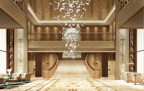 a lobby with a staircase and a chandelier at The Theodore Hanoi in Hanoi