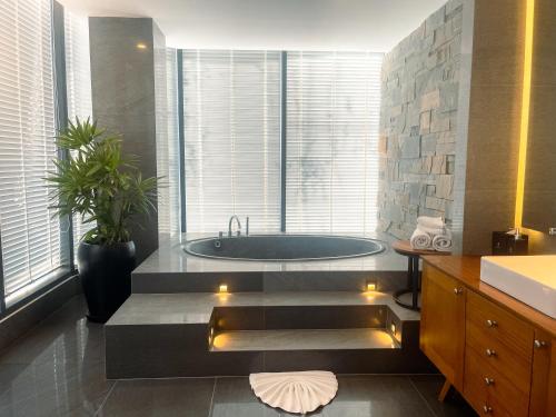 a bathroom with a tub and a large window at Koulen Central Premier Suites in Siem Reap
