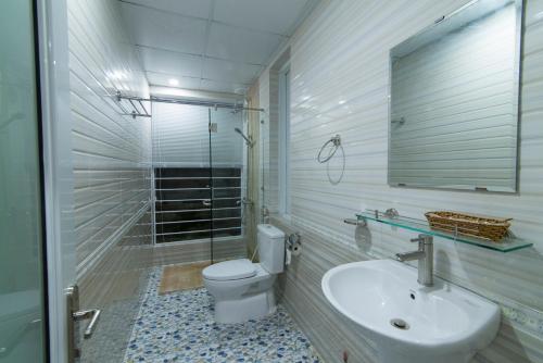 bagno con servizi igienici, lavandino e specchio di Gecko House a Phu Quoc
