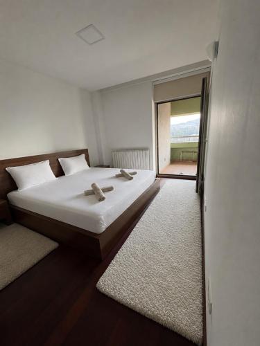 a bedroom with a bed and a sliding glass door at Apartmani delux in Sarajevo