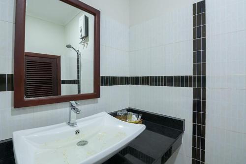 a bathroom with a white sink and a mirror at Raksmey Angkor Boutique in Siem Reap