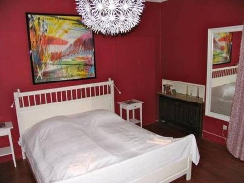 um quarto com uma cama branca e uma parede vermelha em Hemingway`s Heidelberg Hostel em Heidelberg