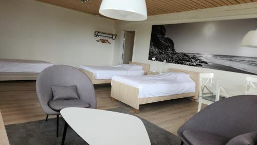 a hotel room with two beds and two chairs at Logies De Vlaschaerd in Heule