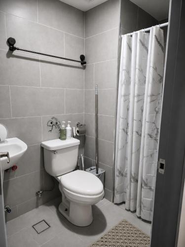 a bathroom with a toilet and a shower curtain at Jtower residences mandaue 27flr in Mandaue City