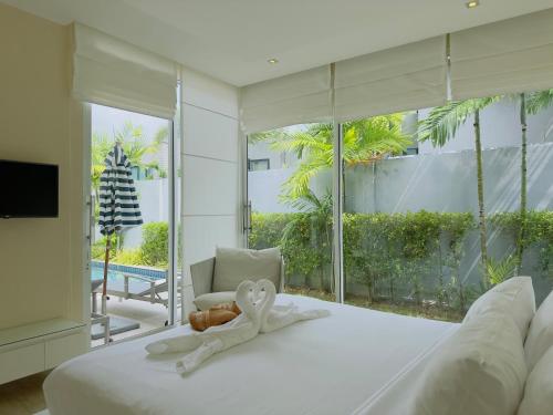 a bedroom with a white bed with a heart on it at 5 Minutes to Naiharn Beach, Private, Quiet and Cozy in Nai Harn Beach