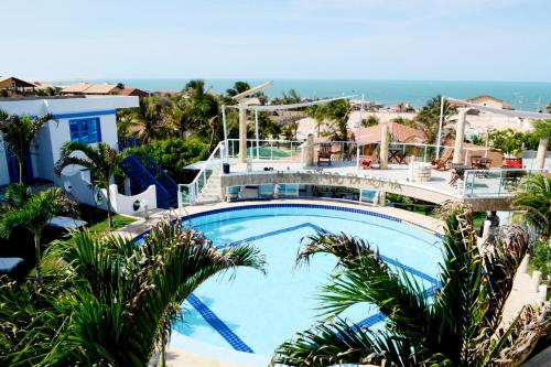 a swimming pool with palm trees in front of a house at Il Mondo Di Sofia in Canoa Quebrada