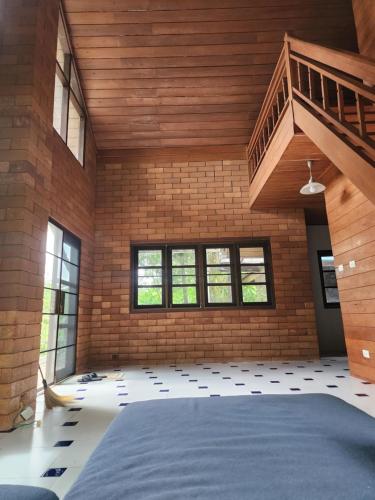 a room with a large bed and a brick wall at Little Bro Mae Hong Son in Ban Mai