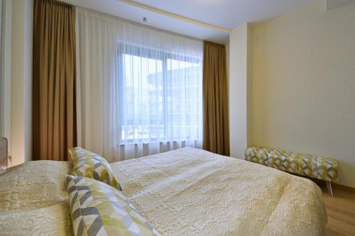 - une chambre avec un lit et une grande fenêtre dans l'établissement 555 SoleSun, à Druskininkai