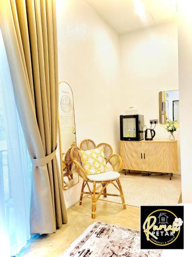 a living room with a chair and a window at Rumah Petak Melor Muji Concept in Melur