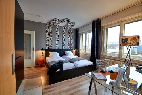 a bedroom with a bed and a glass table at L'aparthoteL LhL in Dijon