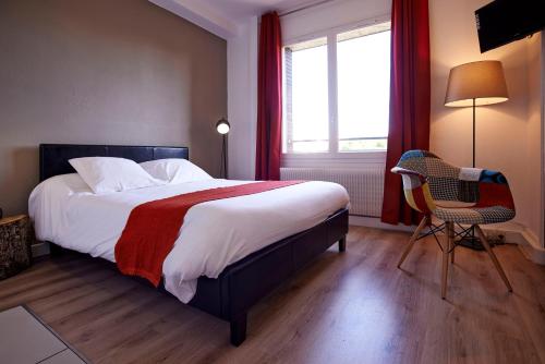 a bedroom with a bed and a chair and a window at L'aparthoteL LhL in Dijon