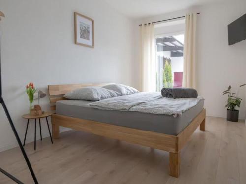a bedroom with a bed in a room with a window at Ferienwohnung Land Leben in Ziertheim