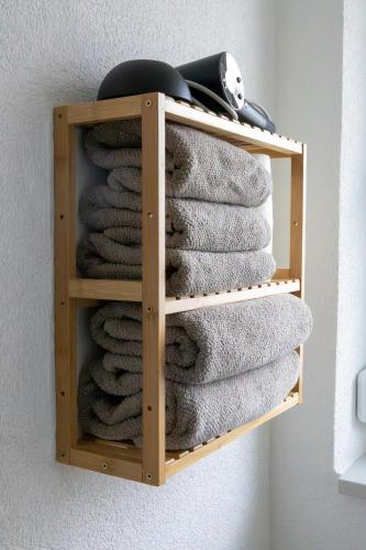 a wooden towel rack with towels on a wall at Ferienwohnung Land Leben in Ziertheim