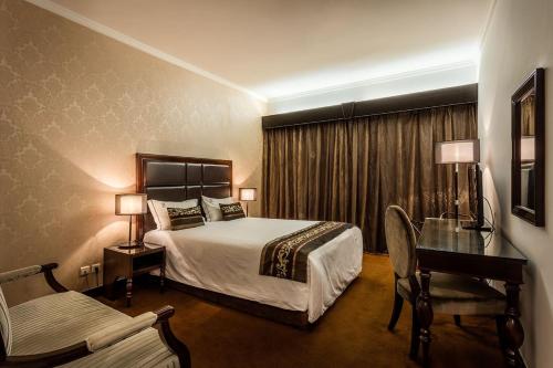 a hotel room with a bed and a desk at Hotel Vip Grand Maputo in Maputo