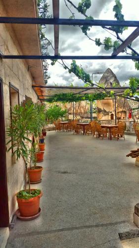 a patio with potted plants and tables and chairs at Elite Cave Suites in Goreme