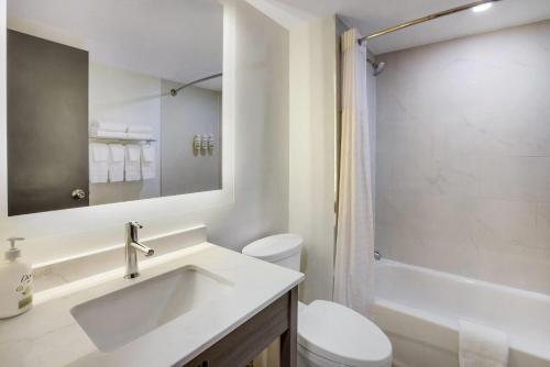 a bathroom with a sink and a toilet and a shower at Ramada by Wyndham Kingston in Kingston
